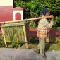 Pasangan tua Katmini dan Harun, warga Kampung Cimaung, Desa Kolot, Kecamatan Cilawu, Garut, Jawa Barat, nampak tengah menggendong kandang ayam untuk diperjualbelikan bagi warga yang membutuhkan. (Liputan6.com/Jayadi Supriadin)