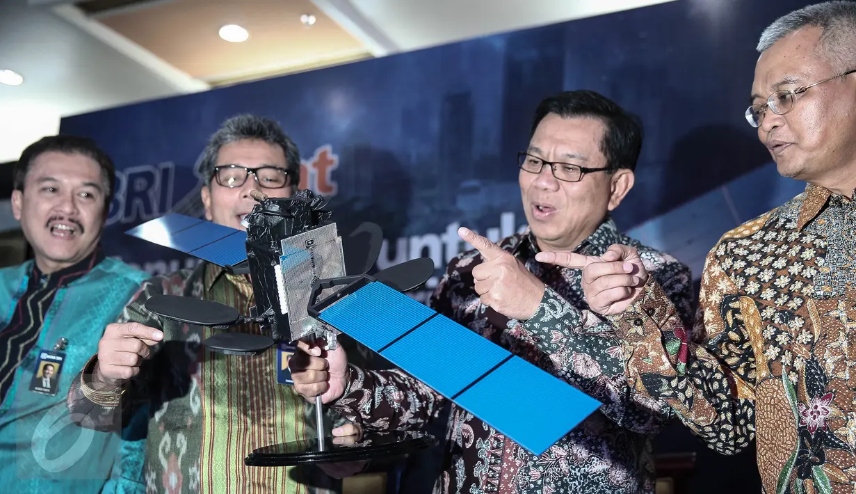 Direktur Utama BRI Asmawi Syam (kedua kanan) menunjukan replika Satelit BRISat saat Launching di Jakarta, (31/5/2016). Nilai investasi satelit ini mencapai Rp 3,375 triliun untuk meningkatkan kualitas layanan menjadi kuat. (Liputan6.com/Faizal Fanani)