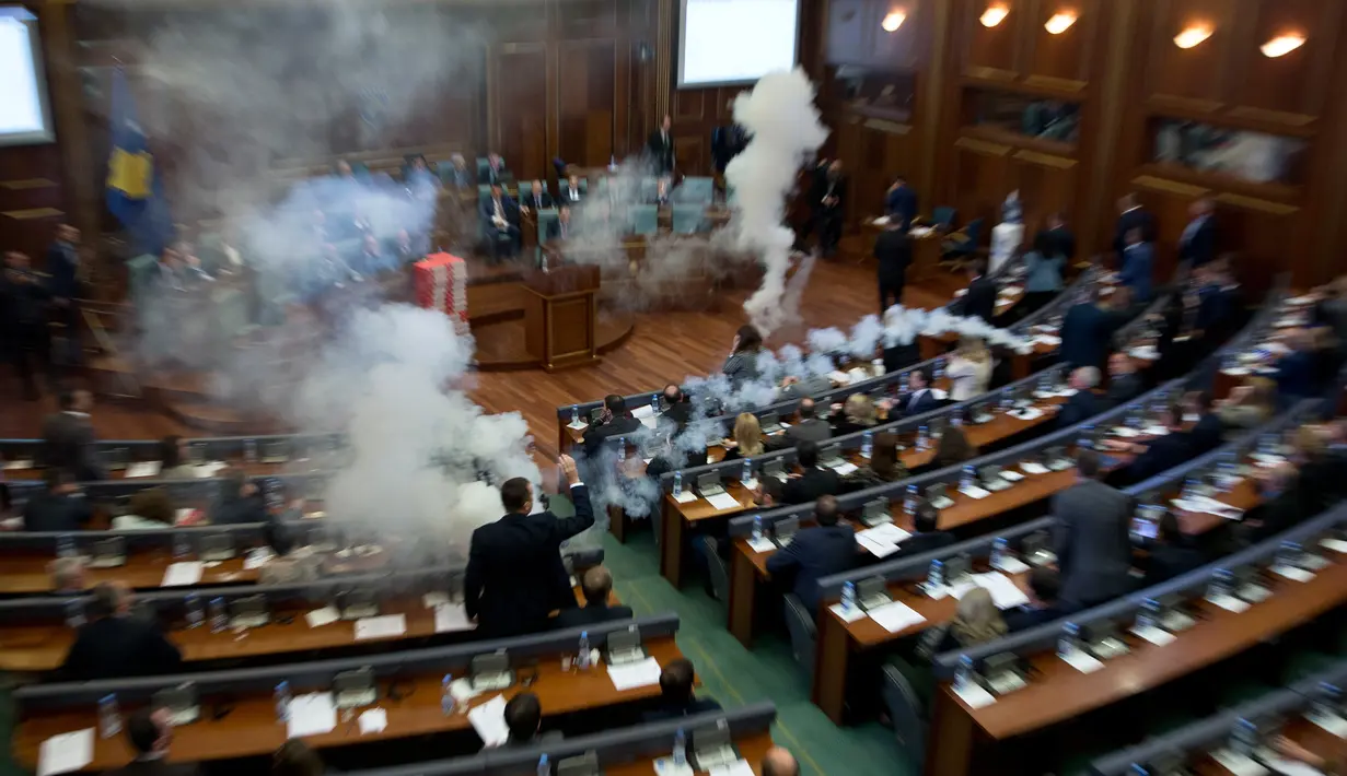 Sebuah gas air mata meledak dalam rapat parlemen di ibu kota Kosovo, Pristina, Rabu (21/3). Aksi anggota Partai Vatevendosje itu dilakukan demi mencegah pemungutan suara terkait masalah kesepatakan perbatasan dengan Montenegro. (AP Photo/Visar Kryeziu)