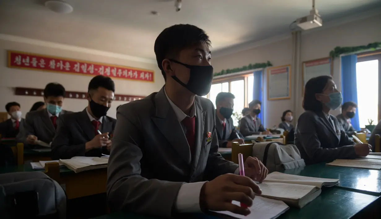 Mahasiswa menghadiri kuliah dengan mengenakan masker sebagai upaya mencegah penyebaran pandemi Covid-19 di Universitas Kedokteran Pyongyang di Pyongyang Rabu (22/4/2020). Korea Utara memberlakukan pembatasan ketat guna mengantisipasi penyebaran virus corona di negara tersebut. (KIM Won Jin/AFP)