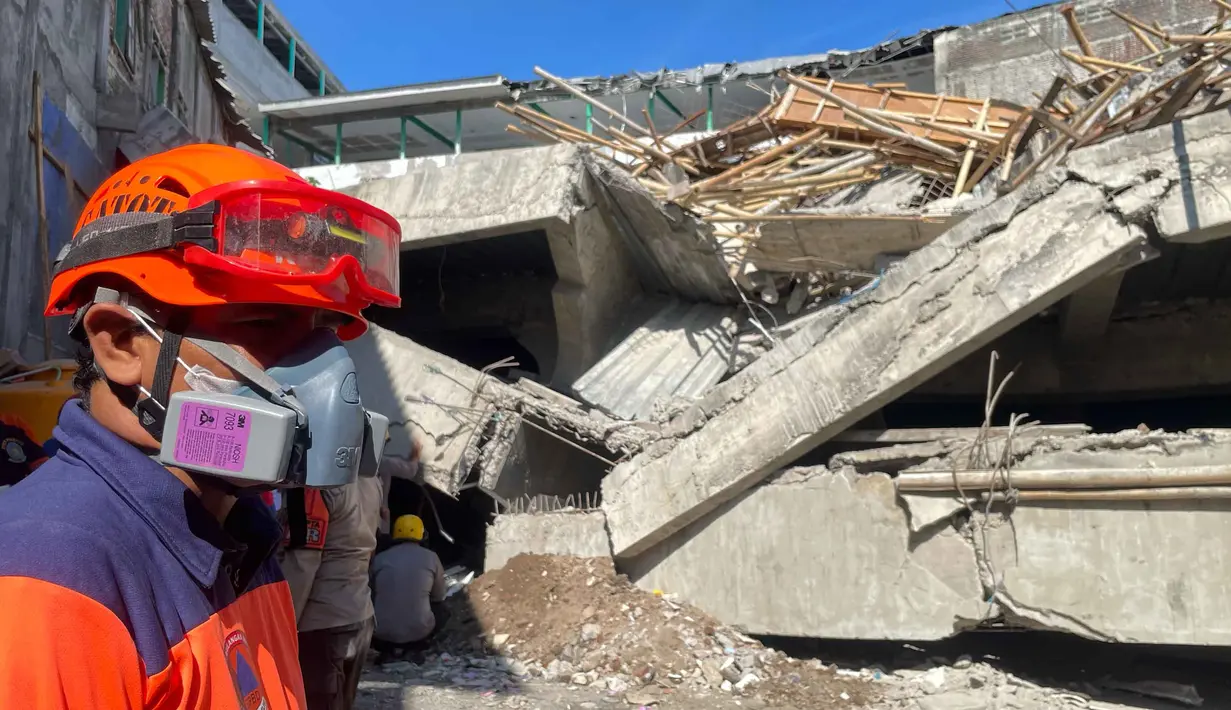 Tim terus melakukan upaya-upaya pencarian dan penyelamatan korban dengan menggali celah di antara puing-puing bangunan maupun membuat lubang untuk akses evakuasi. (AP Photo/Trisnadi)