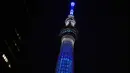 Menara Tokyo Skytree terlihat menyala dengan warna biru bertuliskan "Bersama Kita Semua Bisa Menang" di Tokyo, 5 April 2020. Ungkapan dukungan dan pesan harapan tersebut muncul di tengah merebaknya pandemi virus corona Covid-19. (CHARLY TRIBALLEAU/AFP)