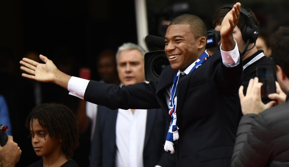 Senyum penyerang baru PSG, Kylian Mbappe (kanan) kepada fans saat perkenalan di Parc des Princes stadium, Paris, (6/9/2017). Mbappe dipinjam PSG dari Monaco dengan opsi permanen sebesar 180 juta euro tahun berikutnya. (AFP/Christophe Simon)
