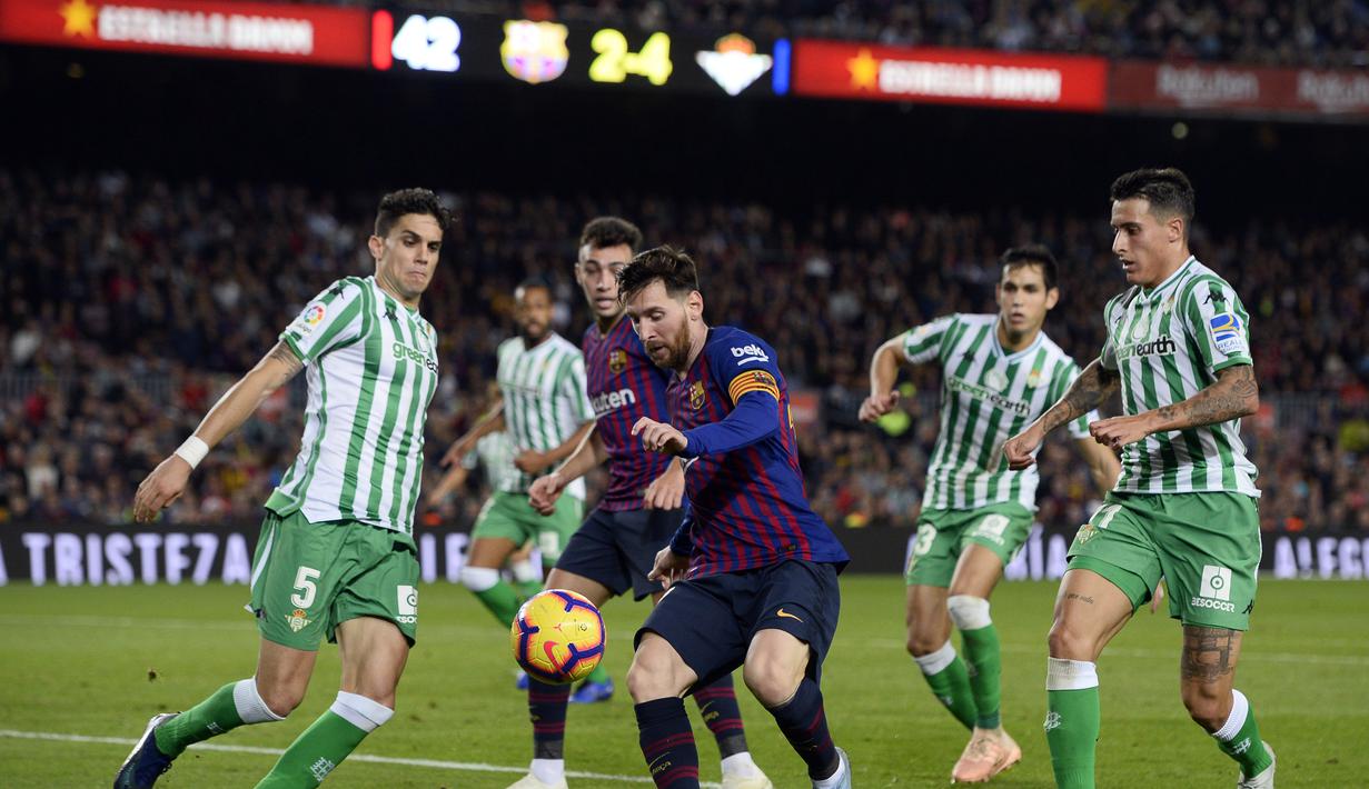 Aksi Lionel Messi yang berhadapan dengan lini pertahanan Real Betis pada laga lanjutan La Liga 2018/19 yang berlangsung di stadion Camp Nou. Barcelona kalah 3-4. (AFP/Josep Lago)