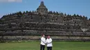 Presiden Indonesia Prabowo Subianto bersama Presiden Prancis Emmanuel Macron menyempatkan berfoto bersama sambil bersalaman berlatar belakang Candi Borobudur. Kedua pemimpin negara kompak mengenakan kemeja bewarna putih. (YASUYOSHI CHIBA/POOL/AFP)
