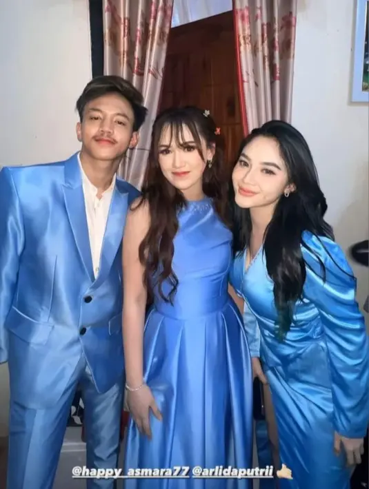 Pelantun lagu “Rungkad” itu tampil memukau dengan sleeveless dress satin berwarna biru yang sama dengan para bridesmaid lainnya. Penampilannya dipermanis dengan tatanan rambut half up do dan hiasan pita warna senada dengan gaunnya. [@happy_asmara77]
