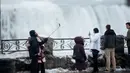 <p>Sejumlah turis mengambil foto di depan Air Terjun Niagara, Ontario, Kanada, Senin (9/1). Air terjun Niagara adalah salah satu tempat wisata andalan Amerika Utara. (Geoff Robins/AFP)</p>