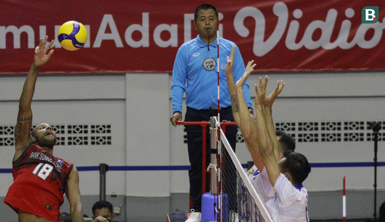 Pemain Palembang Bank Sumsel Babel Caio Alexandre (kiri) berusaha melepaskan smes saat melawan Bogor LavAni pada laga PLN Mobile Proliga 2022 di Padepokan Voli Jenderal Polisi Kunarto, Sentul, Sabtu (29/1/2022). (Bola.com/M Iqbal Ichsan)