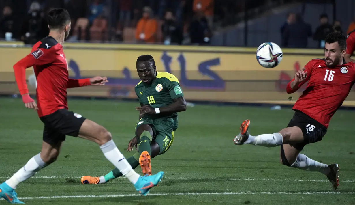 Pemain Senegal Sadio Mane (tengah) mencetak gol saat pemain Mesir Mahmoud Hamdy (kanan) berusaha menghalau pada pertandingan kualifikasi Piala Dunia 2022 di Stadion Internasional Kairo, Kairo, Mesir, 25 Maret 2022. Mesir menang 1-0. (AP Photo/Amr Nabil)