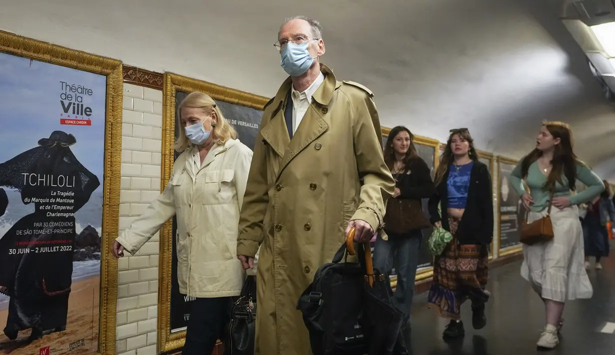 Orang-orang yang memakai masker bergegas ke peron kereta bawah tanah di Paris, Prancis, Kamis (30/6/2022). Dengan turis memadati Paris dan kota-kota lain, pemerintah Prancis merekomendasikan untuk kembali mengenakan masker di transportasi umum dan area ramai tetapi tidak memberlakukan aturan baru. (AP Photo/Michel Euler)