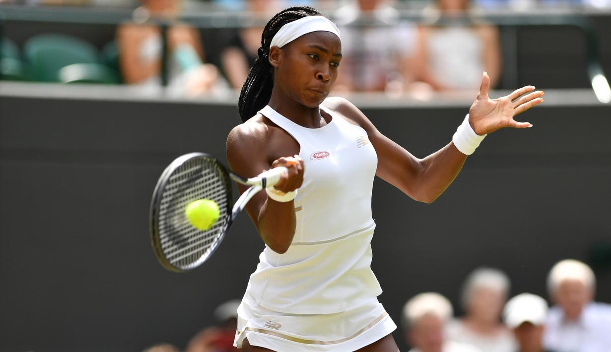 Petenis AS, Cori Gauff mengembalikan bola ke arah lawannya petenis Romania, Simona Halep pada babak keempat Wimbledon 2019 di All England Lawn Tennis Club, Senin (8/7/2019). Petenis berusia 15 tahun itu ditundukkan Halep, yang unggulan ke-7 turnamen, dengan skor 3-6, 3-6. (GLYN KIRK/AFP)
