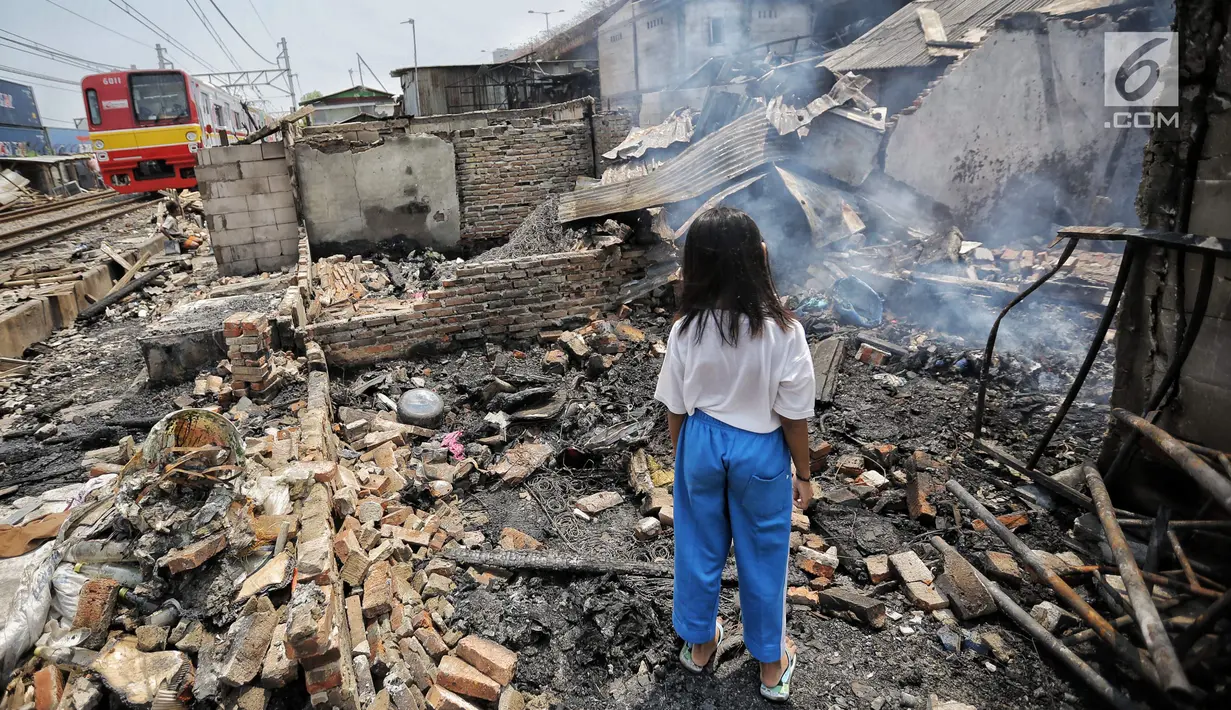Seorang anak mencari sisa sisa barang paska kebakaran di permukiman kumuh di RW 02 Kampung Walang, Lodan Raya, Jakarta, Minggu (25/8). Kondisi Kampung Walang kini porak-poranda. (Liputan6.com/Faizal Fanani)