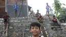 Anak-anak bermain di RPTRA Pelangi Cipedak yang pembangunannya terhenti di Jakarta, Senin (18/3). Terhentinya pembangunan RPTRA yang telah tiga kali mangkrak dikeluhkan warga karena molor dari target yang ditentukan. (Liputan6.com/Immanuel Antonius)
