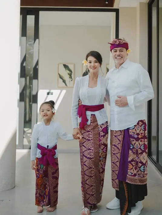 <p>Farah Quinn bersama suaminya, Charles Jost dan Putrinya, Amaira kompak mengenakan pakaian serba putih dan kain khas Bali warna emas keunguan sebagai bawahan saat berada di Bali (@farahquinnofficial)</p>