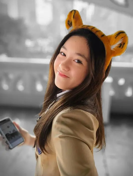 Ia pun tampil begitu manis dengan bando model tiger di atas rambut panjang kecoklatan tanpa poninya. [@nafaurbach]