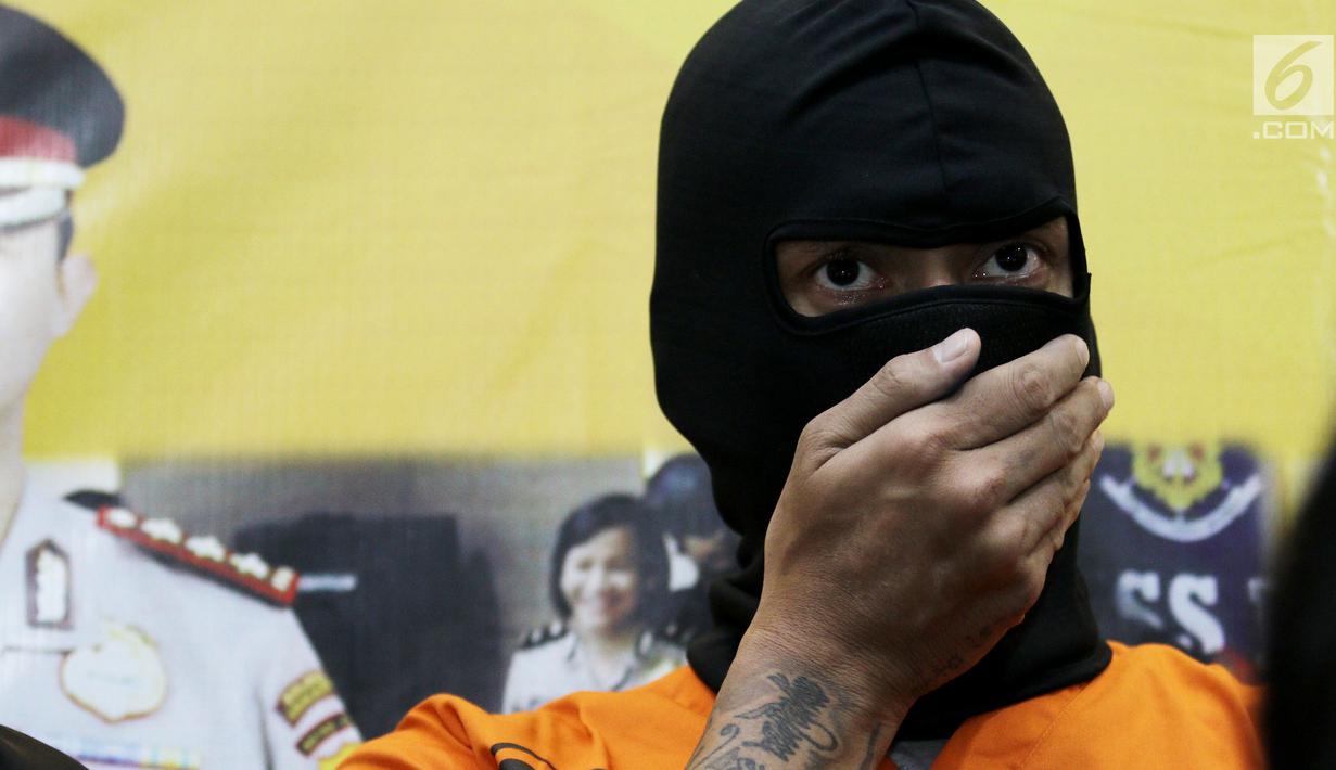 Aktor Tora Sudiro (kenakan penutup wajah hitam) saat dihadirkan dalam jumpa pers kepemilikan psikotropika di Mapolres Jakarta Selatan, Jumat (04/08). Tora dijerat dengan UU Psikotropika tahun 1997 pasal 62. (Liputan6.com/Herman Zakharia)