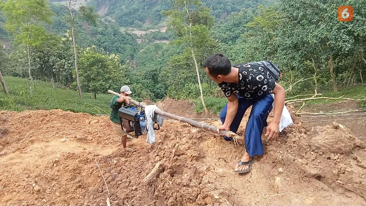 Warga terdampak longsor terisolir di Kecamatan Lengkong, Kabputan Sukabumi saat menggotong genset untuk keperluan air dan listrik yang masih padam, Senin (10/3/2205). (Liputan6.com/Fira Syahrin).