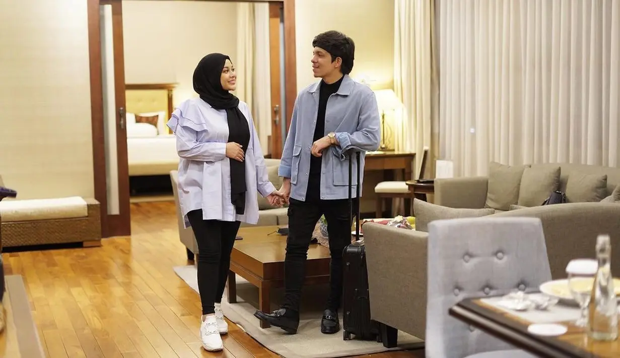 Di sini, Aurelie Hermansyah tampil seragam dengan sang suami. Dengan atasan kemeja biru berlengan rumbai, ia padukan dengan legging dan pashmina hitam, serta sneakers putih polos. Foto: Instagram.
