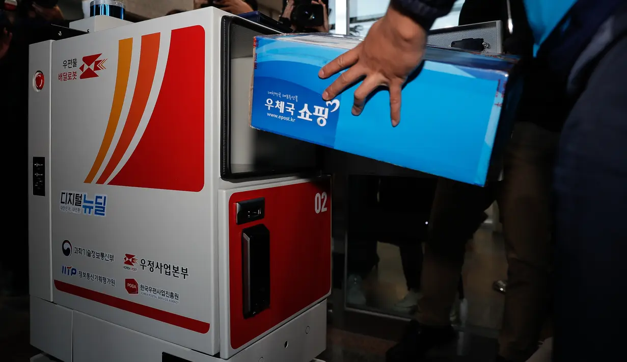 Staf menunjukkan cara kerja robot pengantar di Kampus Sejong Universitas Korea di Kota Sejong, Korea Selatan, pada 28 Oktober 2020. Kampus itu mengadakan acara untuk mendemonstrasikan layanan pengiriman pos dan surat nirawak menggunakan robot otomatis dan kendaraan nirawak. (Xinhua/Wang Jingqiang)