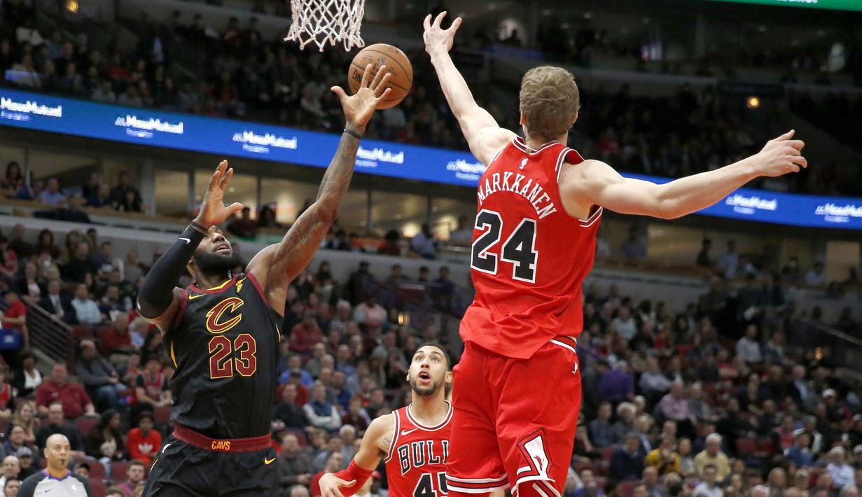 Pebasket Cleveland Cavaliers, LeBron James, berebut bola dengan pebasket Chicago Bulls, Lauri Markkanen, pada laga NBA di United Center, Selasa (5/12/2017). Cleveland Cavaliers menang 113-91 atas Chicago Bulls. (AP/Charles Rex Arbogast)