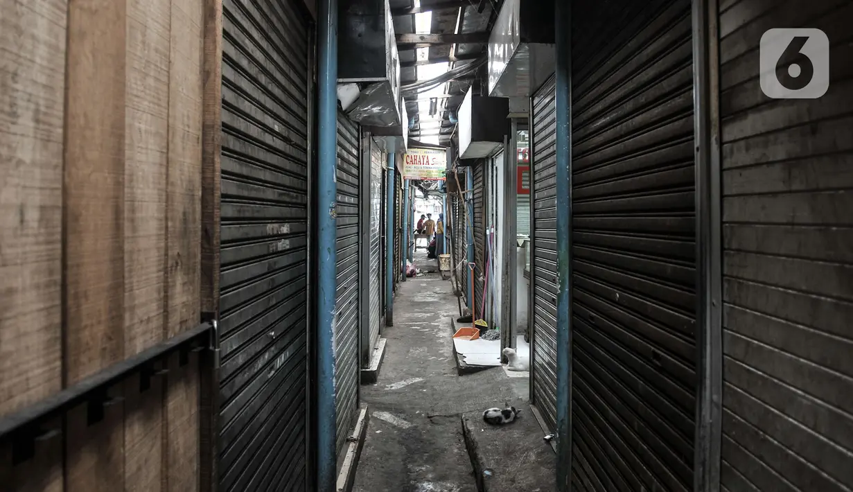 Aktivitas pedagang di dekat deretan kios yang tutup di Pasar Sumur Batu, Kemayoran, Jakarta, Rabu (8/7/2020). Dari 156 pedagang, hingga saat ini baru 30 orang yang mengikuti tes usap. (merdeka.com/Iqbal S. Nugroho)