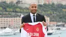 Pelatih AS Monaco, Thierry Henry menunjukkan jersey klubnya saat konferensi pers di Monako, Prancis, Rabu (17/10). Henry resmi melatih AS Monaco menggantikan posisi Leonardo Jardim. (Valery HACHE/AFP)