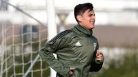 Penyerang Juventus, Paulo Dybala melakukan pemanasan saat mengikuti sesi latihan di Vinovo, Turin, Italia (12/2). Juventus akan bertanding pada babak 16 besar Liga Champions melawan Tottenham Hotspur. (AFP Photo/Miguel Medina)