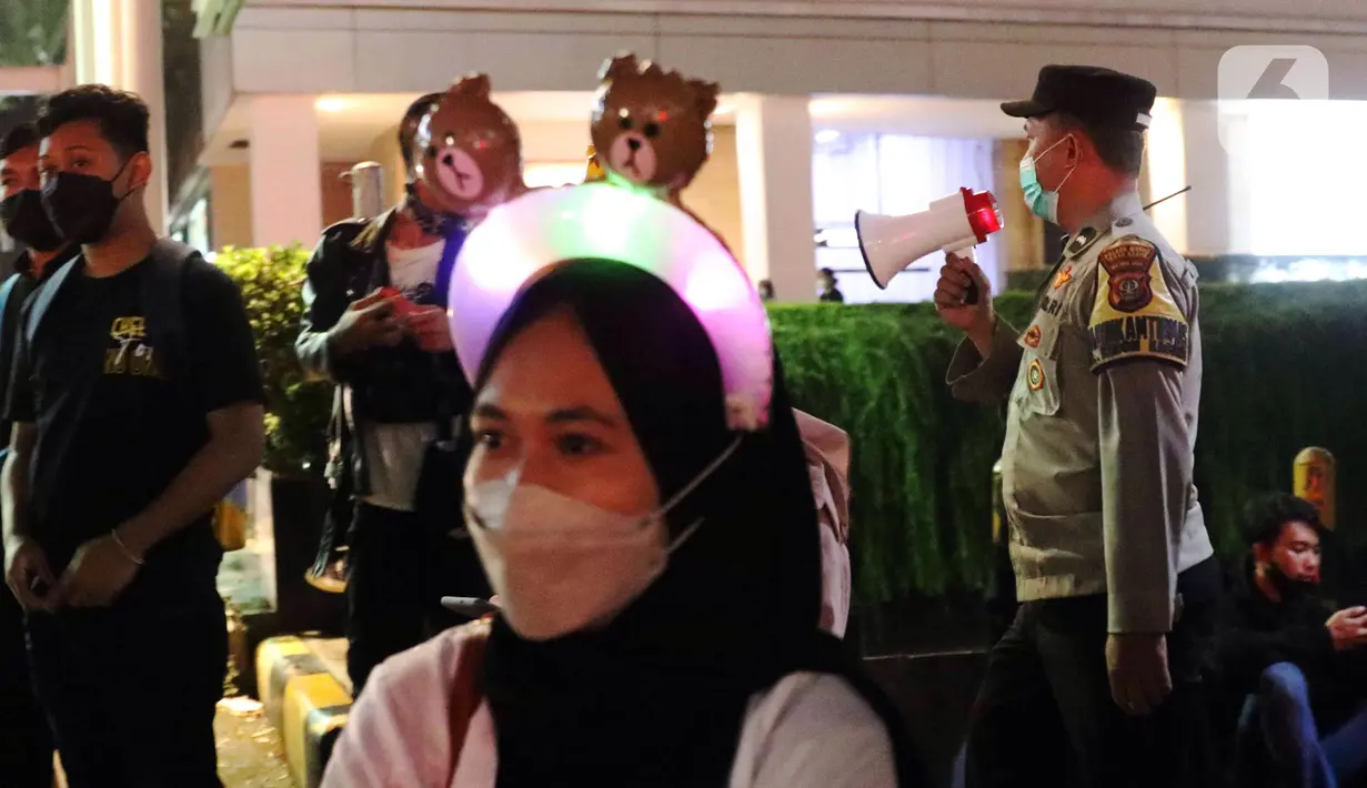 Polisi melakukan pembubaran terhadap warga yang berkerumun di kawasan Bundaran HI, Jakarta, Jumat (31/12/2021). Untuk mencegah penyebaran COVID-19, petugas gabungan melakukan pembubaran aktivitas warga di malam Tahun Baru. (Liputan6.com/Angga Yuniar)