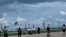 Orang-orang menyaksikan penampilan Jupiter Aerobatic Team TNI AU yang menerbangkan pesawat KT-1 pada pertunjukan udara Singapore Airshow 2022 di Changi Exhibition Centre, Singapura, 15 Februari 2022. Singapore Airshow 2022 berlangsung pada 15 hingga 18 Februari. (ROSLAN RAHMAN/AFP)