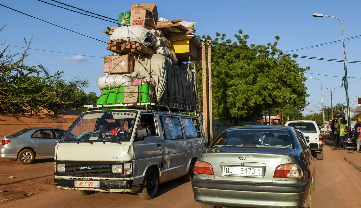 Sebuah mobil van membawa muatan di jalan Niamey, Niger (10/7/2019). Republik Niger adalah sebuah negara yang terkurung oleh daratan di bagian barat Afrika. Niger berbatasan dengan Nigeria dan Benin di sebelah selatan. (AFP Photo/Issouf Sanogo)