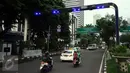 Pengendara melintas di bawah gate ERP di Jalan Jenderal Sudirman Jakarta, Senin (14/12). Meski sudah diuji coba pada pertengahan 2014 lalu, hingga kini penerapan jalan berbayar tersebut masih belum jelas. (Liputan6.com/Helmi Fithriansyah)