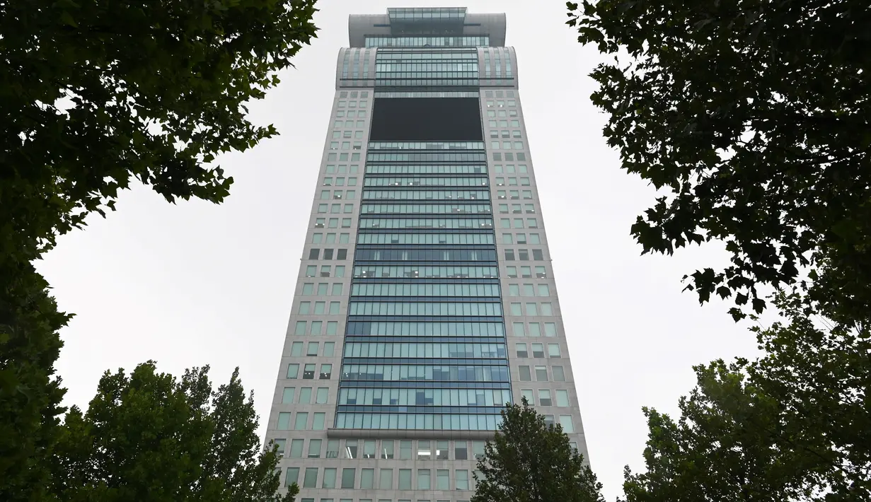 Gedung pencakar langit Pangu Plaza yang mendominasi daerah di seberang Stadion Olimpiade Bird's Nest, Beijing, Selasa (20/7/2019). Gedung yang pernah masuk dalam film Transformers: Age of Extinction itu terjual dalam lelang online dengan harga 734 juta USD (sekitar Rp10,5 triliun). (GREG BAKER/AFP)