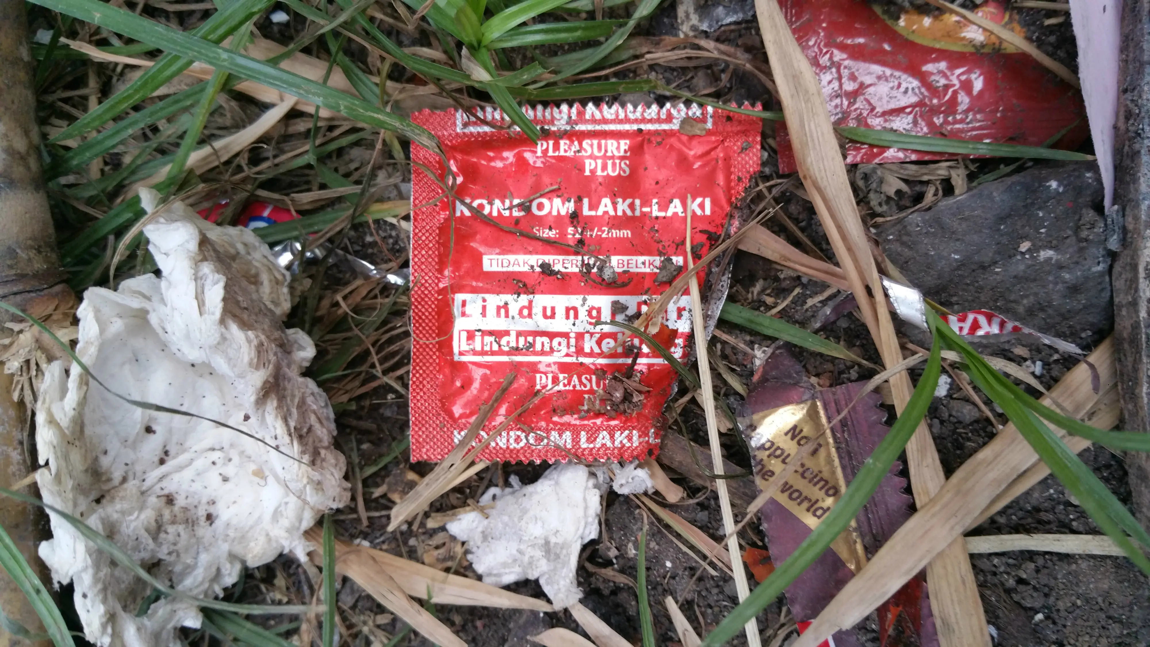 Tempat sampah depan bangunan diduga tempat pesta seks gay di Kelapa Gading banyak berserakan sampah bungkus kondom. (Liputan6.com/Nanda Perdana Putra)