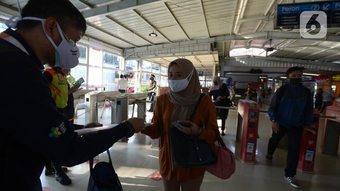 Petugas gabungan membagikan masker kepada calon penumpang  KRL jurusan Jakarta- Bogor di stasiun Tebet, Jakarta, Kamis (27/8/2020). Kegiatan tersebut merupakan rangkaian dari kampanye menggunakan masker di era Adaptasi Kebiasaan Baru untuk menghindari penularan COVID-19. (merdeka.com/Imam Buhori)