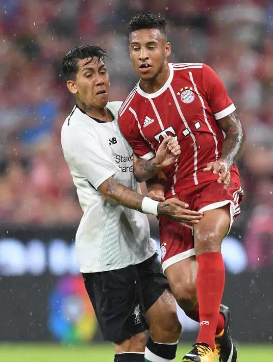 Striker Liverpool, Roberto Firmino, menahan laju gelandang Bayern Munchen, Corentin Tolisso, pada laga Audi Cup di Stadion Allianz Arena, Munchen, Selasa (1/8/2017). Munchen kalah 0-3 dari Liverpool. (AFP/Christof Stache)