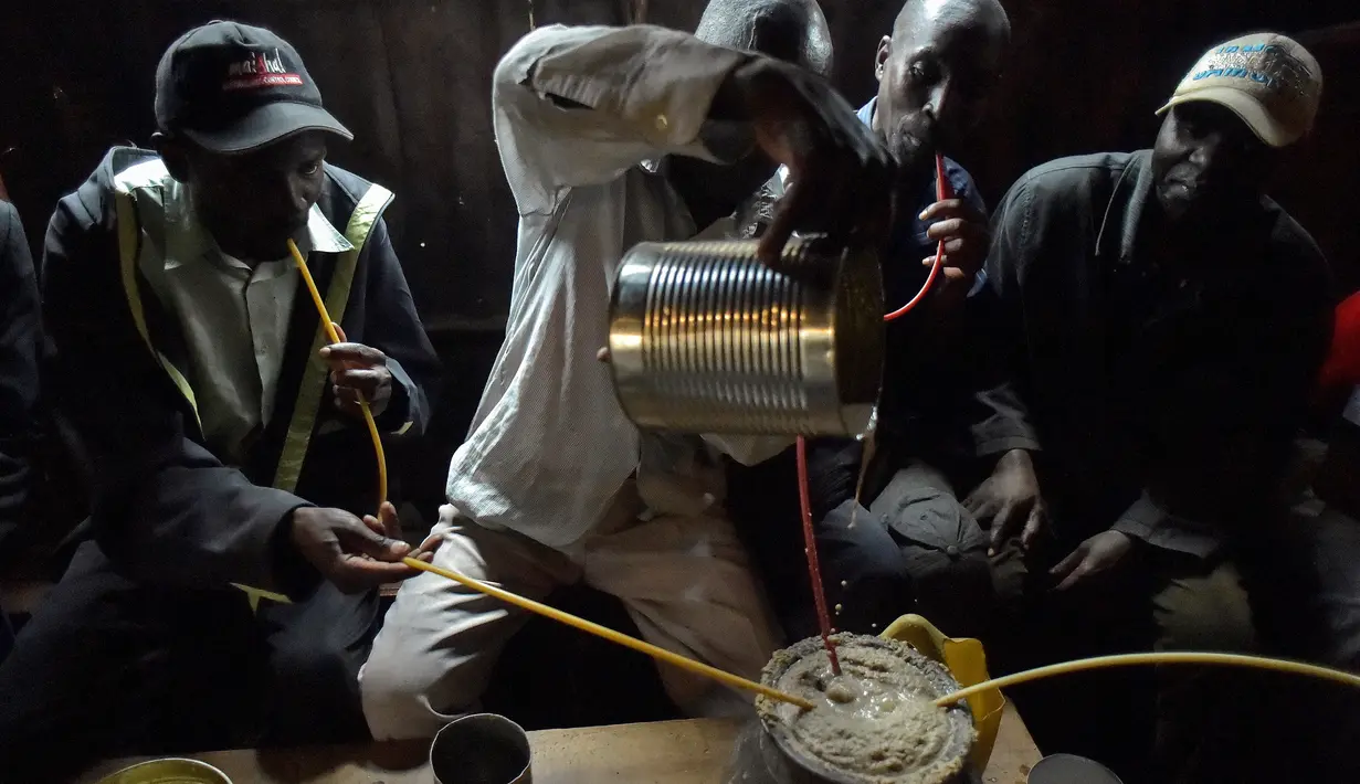 Seorang pria menuangkan racikan minuman beralkohol ke dalam pot di daerah Nairobi, Kenya, Rabu (8/11). Minuman ini adalah bir tradisional Kenya yang terbuat dari dari tepung sorgum, jagung, atau tepung millet. (AFP Photo/Simon Maina)