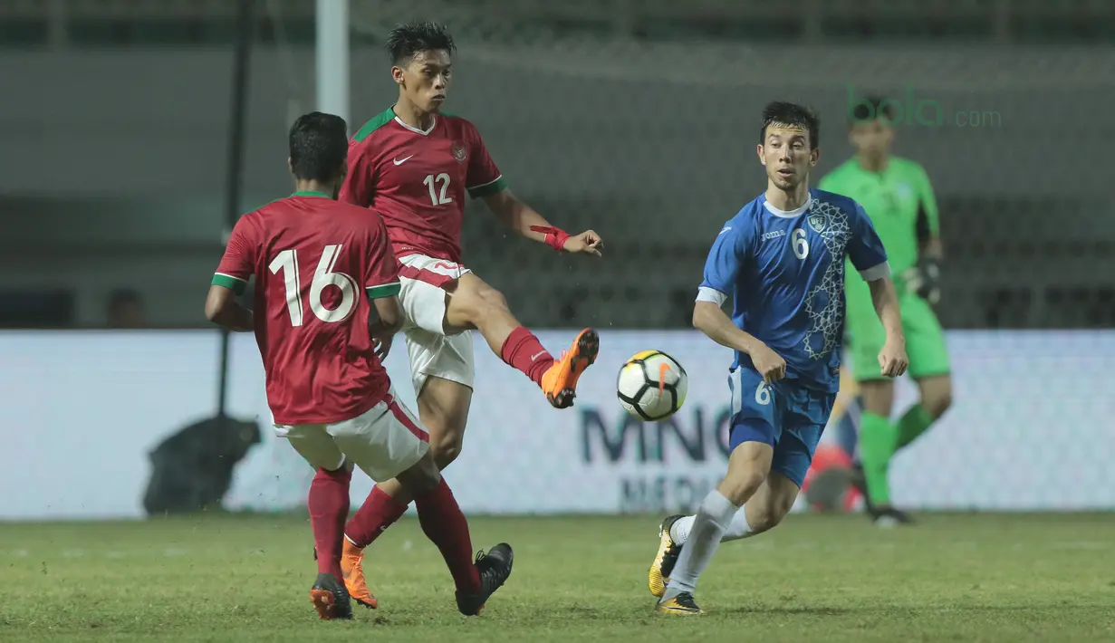 Pemain timnas Indonesia U-23, Lerby Eliandri (tengah) menghalau bola dari kejaran pemain Uzbekistan pada laga PSSI Anniversary Cup 2018 di Stadion Pakansari, Bogor, (03/5/2018). Indonesia U-23 bermain imbang 0-0. (Bola.com/Nick Hanoatubun)