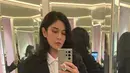 Dian Sastrowardoyo mengenakan blazer hitam oversize dipadukan inner kemeja putih dan mini skirt pleated. Serta belt hitam besar yang menjadi statement. [@therealdisastr]