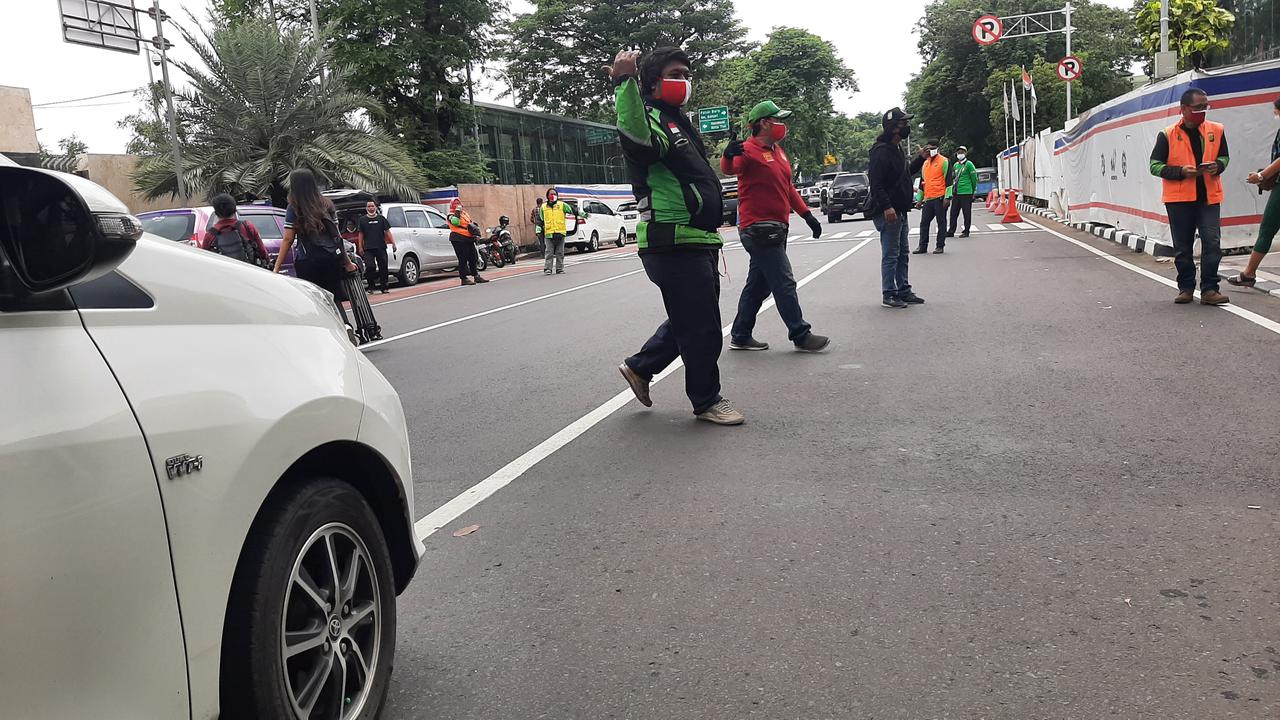 Komunitas ojek online (ojol) membantu mengatur arus lalu lintas di sekitar Gereja Katedral, Jakarta Pusat, Sabtu (25/12/2021).