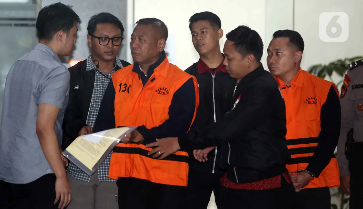 KPK juga menyita sejumlah barang bukti. Barang bukti tersebut di antaranya beberapa dokumen, Barang Bukti Elektronik (BBE), beberapa pasang sepatu, serta uang tunai sebesar Rp 335,4 juta. Tampak dalam foto, Bupati Tulungagung, Gatut Sunu Wibowo (ketiga kiri) dibawa petugas menuju mobil tahahan usai menjalani pemeriksaan intensif di Gedung Merah Putih Komisi Pemberantasan Korupsi (KPK), Jakarta, Minggu (12/4/2026) dini hari WIB. (Liputan6.com/Helmi Fitrhiansyah)