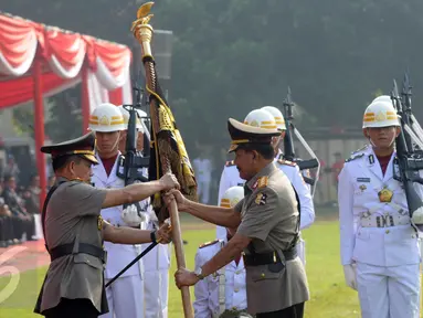 Jenderal Badrodin Haiti menyerahkan panji kepada Jenderal Tito Karnavian dalam upacara sertijab Kapolri di Stadion PTIK, Jakarta, Kamis (14/7). Badrodin Haiti resmi menyerahkan tongkat komando Kapolri kepada Tito Karnavian. (Liputan6.com/Helmi Afandi)