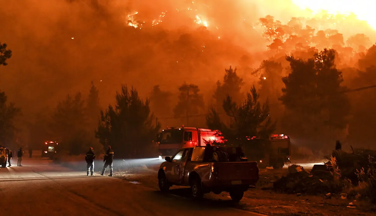 Kesibukan petugas pemadam kebakaran saat api berkobar dalam kebakaran di dekat Desa Schinos, dekat Korintus, Yunani, Rabu (19/5/2021). Delapan pesawat dan tiga helikopter diterjunkan untuk menjatuhkan air ke titik api.  (AP Photo/Valerie Gache)