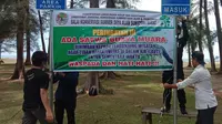 BKSDA Resor Agam memasang spanduk peringatan ada buaya muara di Pantai Tiku. (Liputan6.com/ BKSDA Agam)