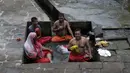 Umat Hindu melakukan ritual selama gerhana matahari di Banganga, Mumbai, India, Minggu (21/6/2020). Fenomena gerhana matahari pada 21 Juni 2020 terlihat dari berbagai negara di dunia. (AP Photo/Rajanish Kakade)