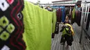 Pekerja mengangkat kain sasirangan yang telah dijemuri di kawasan Banjarmasin, Kalimantan Selatan, Senin (26/3). Kain sasirangan ini diwariskan secara turun temurun sejak abad XI. (Liputan6.com/Immanuel Antonius)