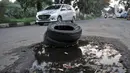 Ban bekas untuk menutupi jalan berlubang di Jalan Tegar Beriman, Cibinong, Bogor, Minggu (31/5/2020). Sudah berbulan-bulan akses yang dikenal sebagai jalan Pemda Cibinong ini sangat memprihatinkan hingga sering menyebabkan kecelakaan terlebih saat musim hujan. (merdeka.com/Iqbal Nugroho)