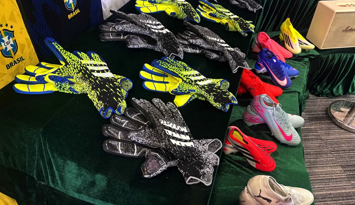 Sarung tangan dan sepatu bot sepak bola dipamerkan oleh otoritas bea cukai Hong Kong dalam konferensi baru tentang barang palsu dan pelanggaran di kantor pusat mereka di North Point, Hong Kong Kamis 11 Juni 2026. (AP Photo/Kanis Leung)