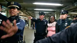 Petugas NYPD menangkap seorang perempuan tersangka pelaku pendorongan di stasiun Time Square, New York, Senin (7/11). Tersangka mendorong seorang perempuan hingga tewas ke jalur subway (kereta bawah tanah) . (REUTERS/James Carman)