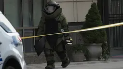 Penjinak bom berjalan usai mengambil paket mencurigakan di dekat Hilton Garden Hotel di Washington, DC.AS (19/1). Donald Trump akan menjadi Presiden AS ke-45 yang akan dilantik pada 20 Januari 2017. (AFP Photo/Andrew Caballero-Reynolds)
