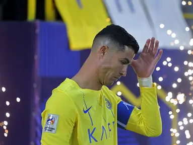 Pemain Al-Nassr, Cristiano Ronaldo berjalan memasuki lapangan saat laga 16 besar Liga Champions Asia 2023/2024 melawan Al-Feiha di Al-Awwal Park Stadium, Riyadh, Arab Saudi Rabu (21/02/2024) waktu setempat. (AFP/Fayez Nureldine)